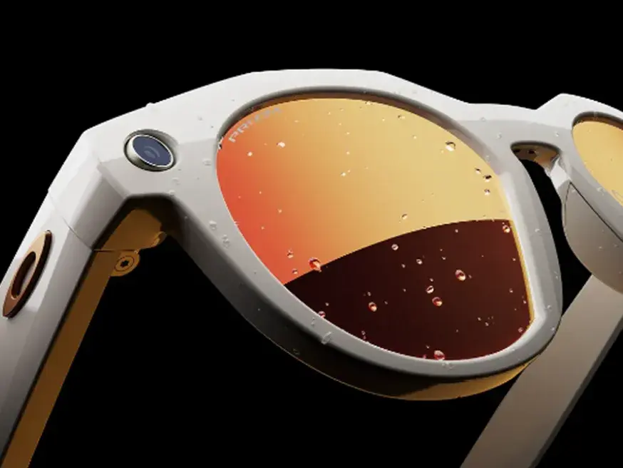 A close-up view of stylish smart sunglasses with orange mirrored lenses, water droplets on the surface, and a built-in camera on the frame.